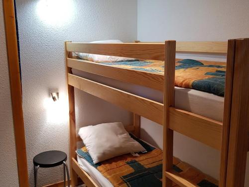 Cette chambre comprend 2 lits superposés et un tabouret. dans l'établissement Appartement rénové 3 pièces avec garage - La Joue du Loup - FR-1-504-158, à Saint-Étienne-en-Dévoluy