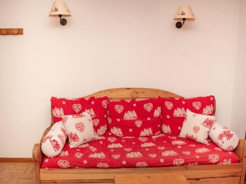 eine rote Couch in einem Zimmer mit Kissen in der Unterkunft Appartement Puy-Saint-Vincent, 2 pièces, 6 personnes - FR-1-504-170 in Puy-Saint-Vincent