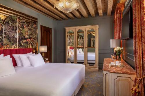 a bedroom with a large white bed and a mirror at NH Collection Grand Hotel Palazzo Dei Dogi in Venice