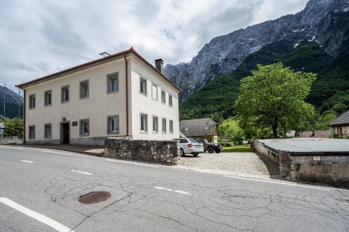 a building on the side of a road with a mountain at Hostel Kronotop in Triglav National Park in Log pod Mangartom