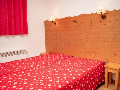 Un dormitorio con una cama roja con una manta roja y blanca en Appartement Puy-Saint-Vincent, 2 pièces, 4 personnes - FR-1-504-260, en Puy-Saint-Vincent