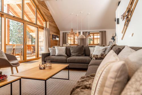 a living room with a couch and a table at Luxury Chalets Gradenbach near Schladming in Haus im Ennstal