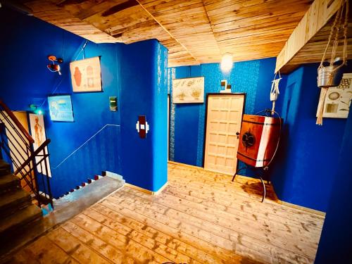 a room with a blue wall and a tv in it at HARABURDI® Recyclart Hotel in Kostelec nad Orlicí