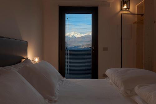 a bedroom with two beds and a window with a view at Agriturismo B&B Caffè e Vino in Sondrio