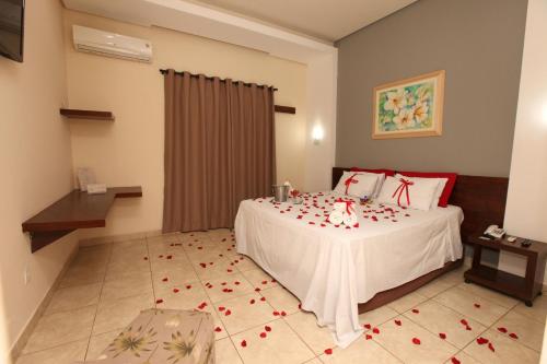 a bedroom with a bed with roses on the floor at IPÊ PARK Convention Hotel in Sao Jose do Rio Preto