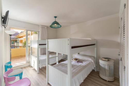 a small room with two bunk beds and a chair at Houmi Sotogrande in Sotogrande