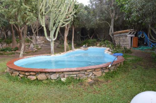 una piscina en un patio con una pared de piedra en Giardino degli Ulivi, en Gonnesa
