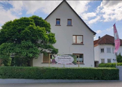 a white house with a sign in front of it at Ferienwohnung im Garten Eden in Grünberg