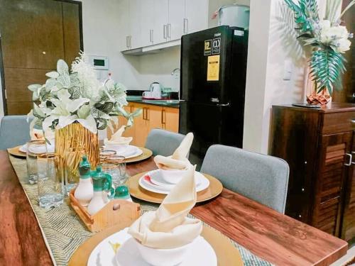 a kitchen with a table with white dishes on it at Homey-feel Studio Unit @ Lafayette Park Square Condominium in Iloilo City