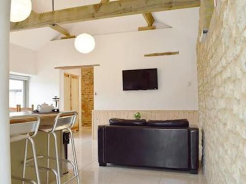 a living room with a counter and a tv on the wall at Mole Hole in Towcester
