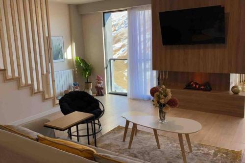a living room with a couch and a table at Duplex in four seasons new gudauri near gondola in Gudauri
