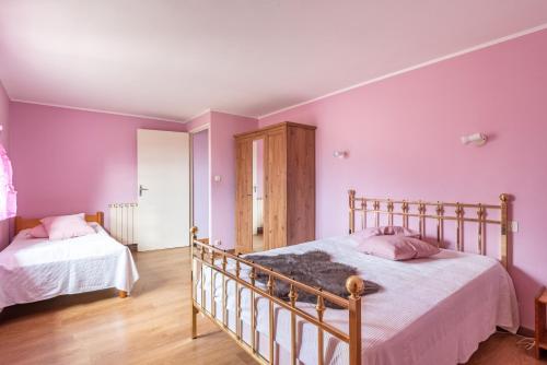 2 Betten in einem Schlafzimmer mit lila Wänden und Holzböden in der Unterkunft L'Espedes in Ruoms