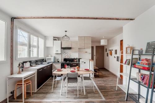 une cuisine avec une table et des chaises dans une pièce dans l'établissement Moulin de Montesquieu, à Agen