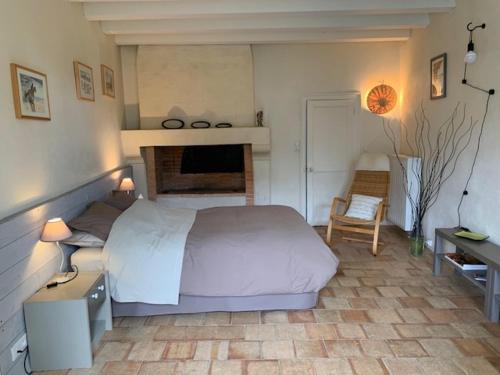 1 dormitorio con 1 cama, 1 mesa y 1 silla en LA PONCÉ SECRÈTE en Poncé sur Le Loir