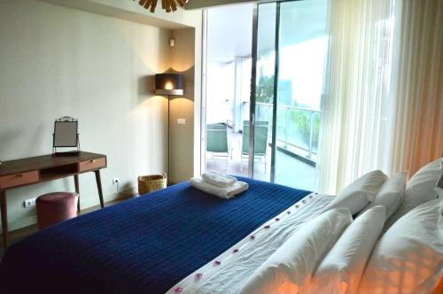 a bedroom with a large bed and a desk and a window at Peaceful Madeira Palace in Funchal
