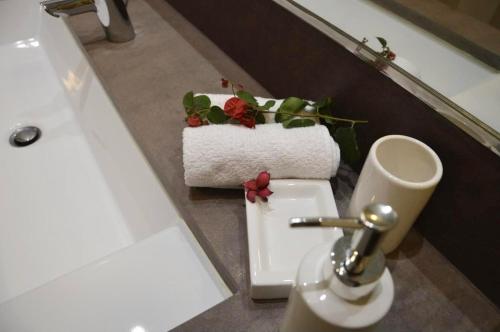 ein Badezimmer mit einem Waschbecken und einem WC mit Blumen darauf in der Unterkunft Peaceful Madeira Palace in Funchal
