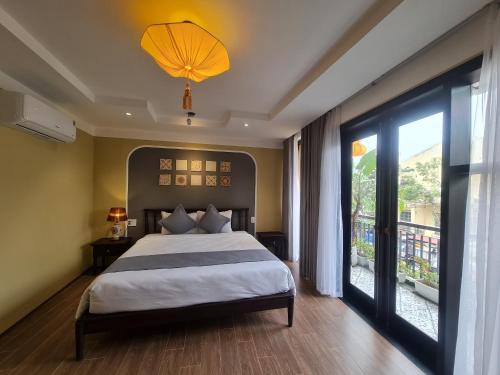 a bedroom with a bed and a large window at Hoianan Boutique Hotel in Hoi An