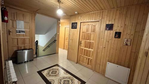 un pasillo con paredes y puertas de madera y suelo de baldosa en Na Dolinie, en Bukowina Tatrzańska