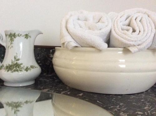 a white bowl with towels in it on a counter at Hotel "Cafe Verkehrt" - Wellcome Motorbiker, Berufsleute und Reisende im Schwarzwald in Oberhof