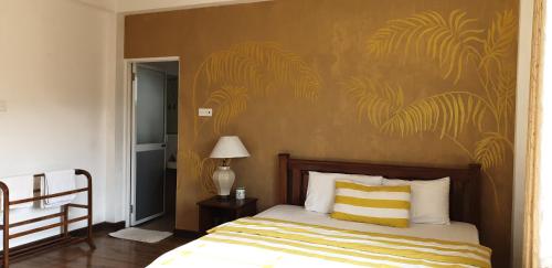 a bedroom with a bed with a yellow and green wall at Medalin Lake Gregory in Nuwara Eliya
