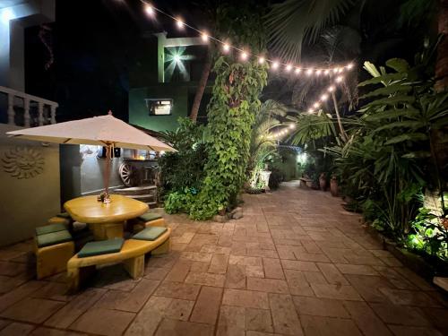 a patio with a table and chairs and lights at Casa Da Praia in Candolim