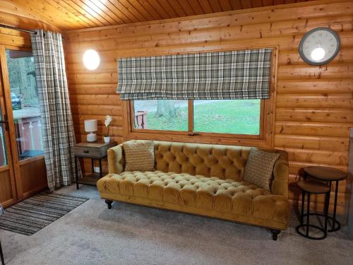 a living room with a couch and a clock at Parkwood Lodge in Louth