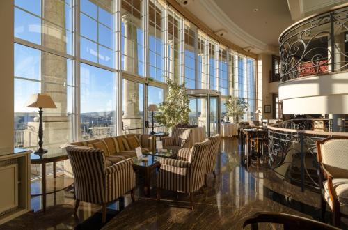 a lobby with chairs and tables and large windows at Gran Hotel Los Abetos in Santiago de Compostela