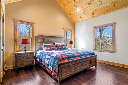 a bedroom with a bed and two windows at Rustic Retreat in Ellijay