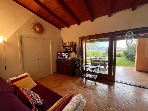a living room with a couch and a sliding glass door at CAPO CODA CAVALLO VILLA SALINEDDA GIARDINO VISTA MARE in Capo Coda Cavallo