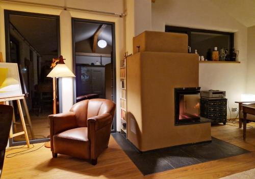 a living room with a chair and a refrigerator at Holzhaus mit Kamin - Am Forellenfluss 