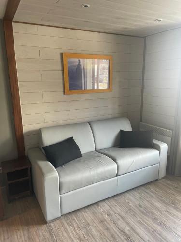 a white couch in a room with a wall at Appart 4/5 pers résidence 4* des Bergers pieds des pistes in L'Alpe-d'Huez