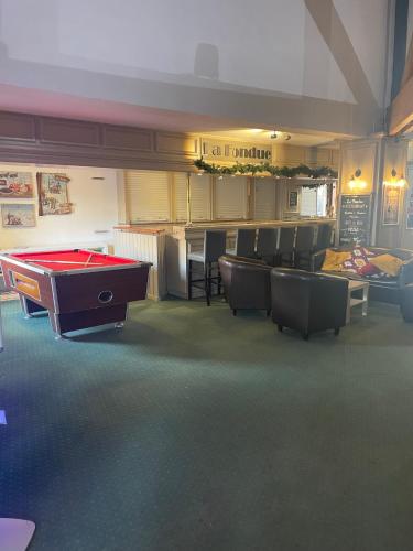 a room with a pool table and some chairs at Appart 4/5 pers résidence 4* des Bergers pieds des pistes in L'Alpe-d'Huez