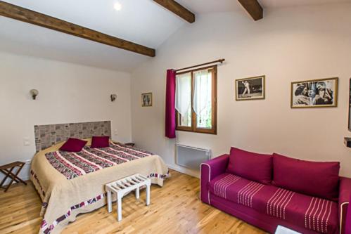 a bedroom with a bed and a purple couch at La Garde Pile de Fichou in Bajamont