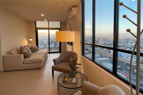 a living room with a couch and chairs in a building at Exclusivo departamento a un lado de la Arena Mty, Fundidora y Cintermex in Monterrey