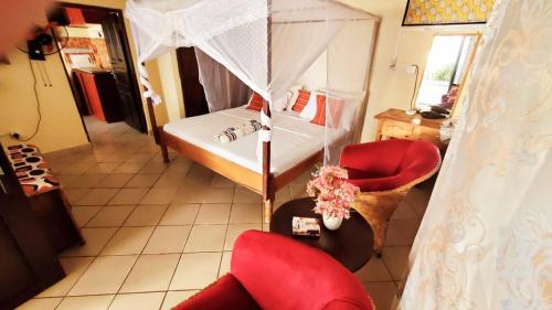 een slaapkamer met een bed, een stoel en een paraplu bij Charming and Remarkable 1 Bed Villa in Diani Beach in Diani Beach