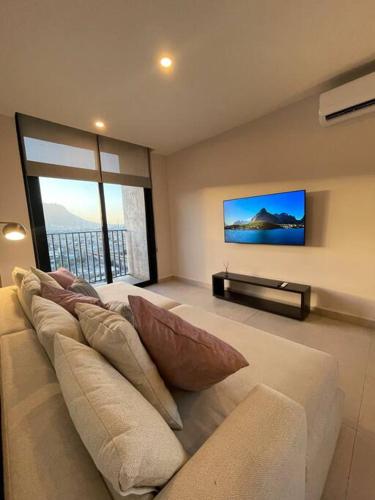 a living room with a couch with pillows on it at Exclusivo departamento a un lado de la Arena Mty, Fundidora y Cintermex in Monterrey