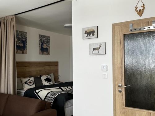 a bedroom with a bed and a door with a window at KLINOVEC APARTMENTS LUXURY in Loučná pod Klínovcem