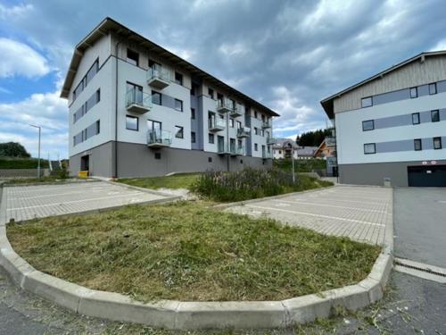 an empty parking lot in front of a building at KLINOVEC APARTMENTS LUXURY in Loučná pod Klínovcem