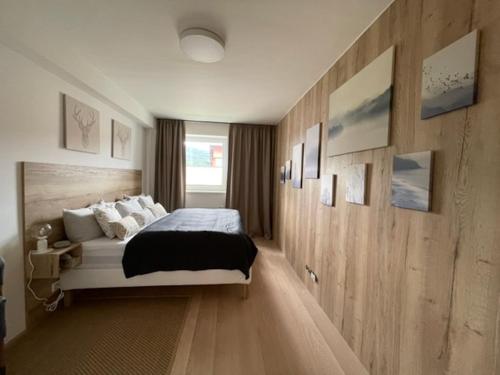a bedroom with a large bed and wooden walls at KLINOVEC APARTMENTS LUXURY in Loučná pod Klínovcem