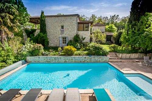 a swimming pool in front of a house at La Garde Pile de Fichou in Bajamont