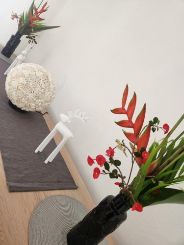 a table with a vase with a plant and a man doll at Kaz Memel in Beau Vallon