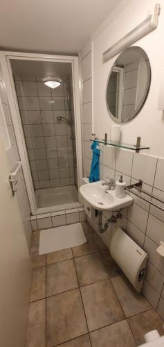 ein Bad mit einem Waschbecken und einer Dusche in der Unterkunft Ferienwohnung Bronder in Homburg