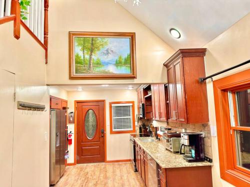 a large kitchen with a door and a painting on the wall at Chic Chalet River Views & Access 