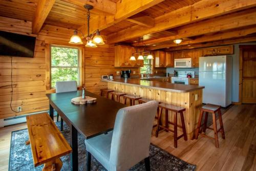 a kitchen with a table and chairs and a refrigerator at The Hive at Blue Spruce Lodge White Mnts View in Brownfield