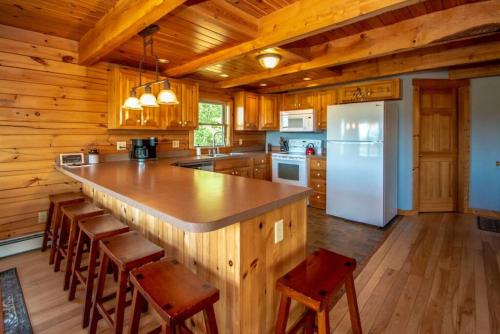 a kitchen with a large island in a cabin at The Hive at Blue Spruce Lodge White Mnts View in Brownfield