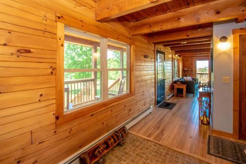 a log cabin hallway with a large window at The Hive at Blue Spruce Lodge White Mnts View in Brownfield