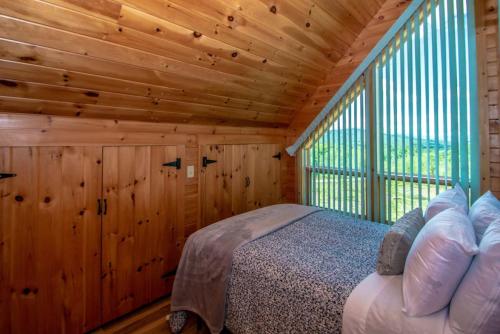 a bedroom with a bed in a wooden cabin at The Hive at Blue Spruce Lodge White Mnts View in Brownfield