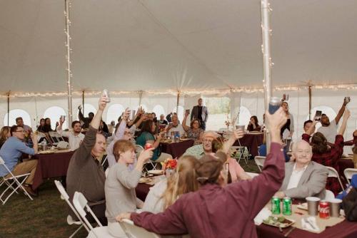 a group of people sitting in a tent with their hands in the air at Big Sky Mountain Estate in Brownfield