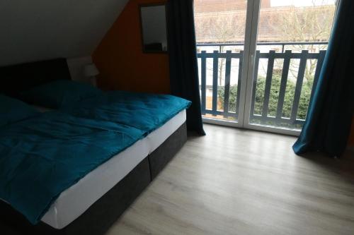 a bed sitting in a room with a balcony at Holiday in Schwandorf in Bayern