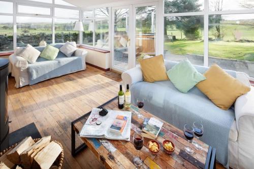 a living room with a couch and a table at Bush Nook Farmhouse in Brampton